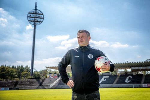 Marek Kulič stojí na fotbalovém stadionu v Hradci Králové a drží míč