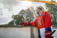 Petr Novák stojí u hokejbalového hřiště v českém dresu s hokejkou