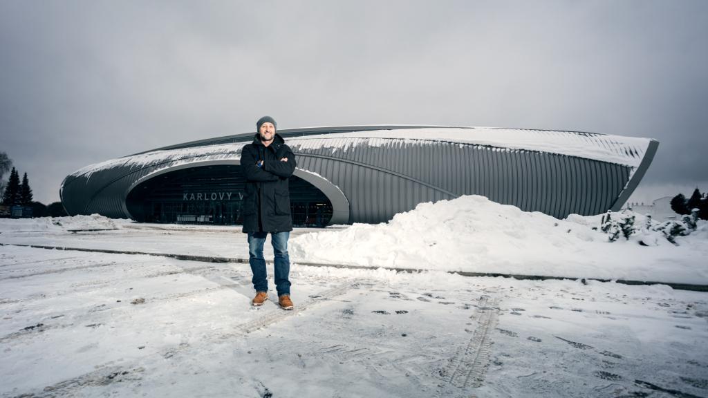 Petr Kopfstein stojí před letištěm Karlovy Vary v zimě