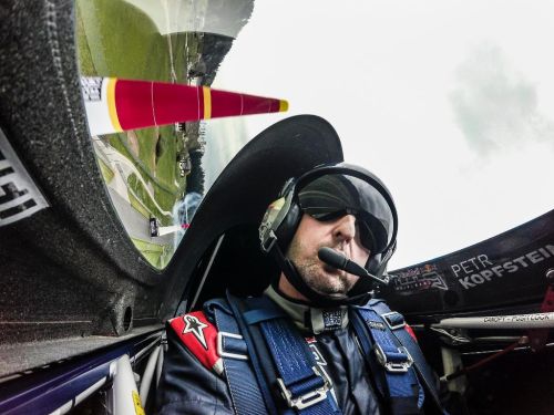 Petr Kopfstein s helmou a mikrofonem v letadle, při proletu mezi kužely při závodech