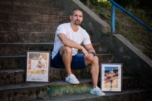 Tomáš Plekanec sedí na schodech se zarámovanými fotkami.
