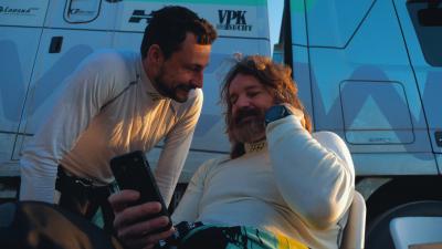 Ondřej Klymčiw kouká na kolegu, který se kouká do telefonu před kamionem