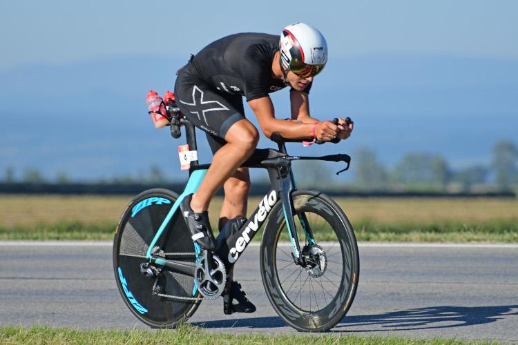 Tomáš Řenč jede na kole při triatlonovém závodě