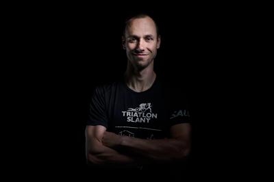 Tomáš Řenč v tričku triatlon Slaný s černým pozadím