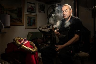 Jiří Císař kouří dýmku, kouká na staré obrazy, má před sebou trofej