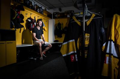 Viktor Hübl sedí v hokejové šatně HC Litvínov mezi výstrojí s dresy