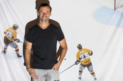 Viktor Hübl stojí před plátnem, kde je promítán hokej Litvínova