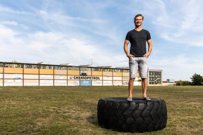 Viktor Hübl stojí na velké pneumatice před hokejovým stadionem 
