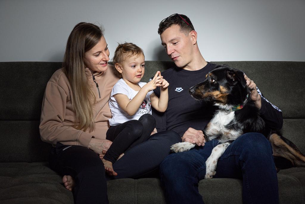 Jan Micka se svou manželkou, dcerou a psem na gauči.