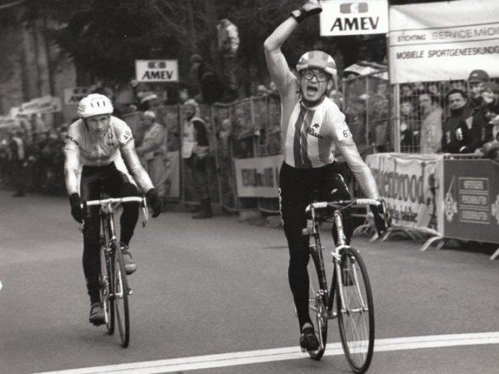 Radomír Šimůnek při závodě na kole, za ním fanoušci