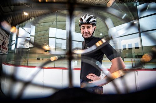 Radomír Šimůnek s cyklistickou helmou na hokejovém stadionu, pohled z hokejové přilby 