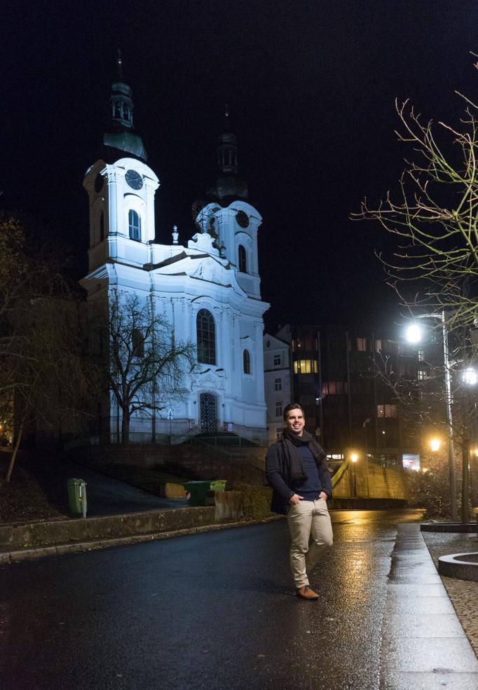 Lukáš Tintěra stojí večer na silnici před kostelem