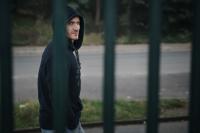 Michal "Háša" Hamršmíd stojí za plotem v mikině s kapucou na hlavě