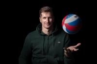 portrétní fotka Jana Štokra s volejbalovým míčem na černém pozadí