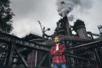Tomáš Marcinko stojí před továrnou třineckých železáren.