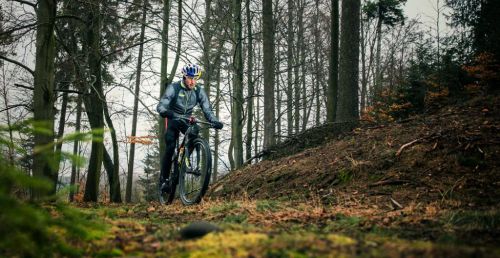Jan Kubíček jede lesem na kole