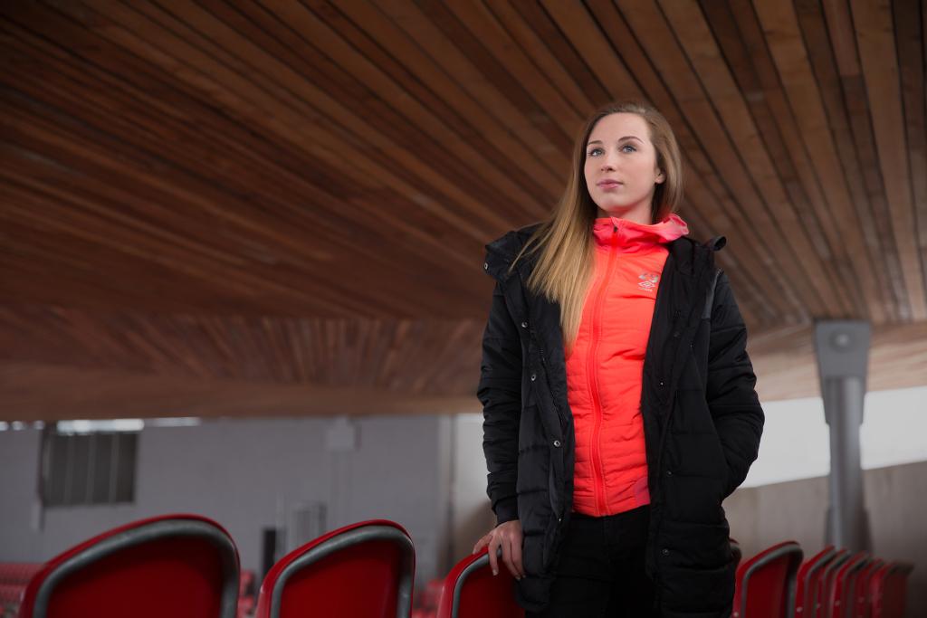 Barbora Votíková stojí opřená o sedadla pro diváky