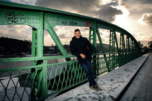 Josef Dostál opřený o zábradlí na mostu