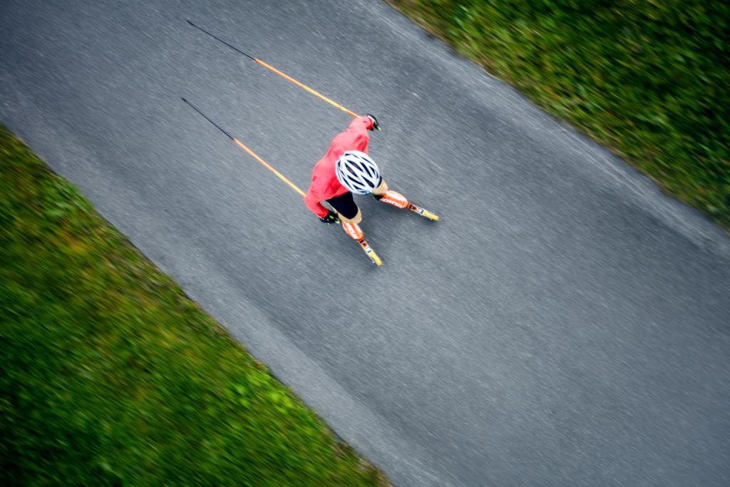 Lukáš Bauer jede po silnici na kolečkových lyžích.