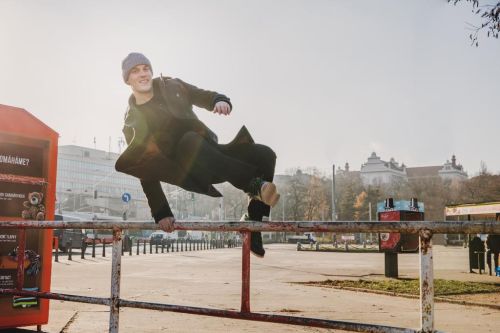 Tomáš Verner skáče přes zábradlí ve městě