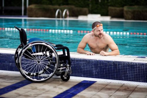 Jan Povýšil v bazénu vedle svého vozíku