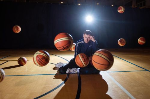 Pavel Miloš obklopen padajícím basketbalovými míči.