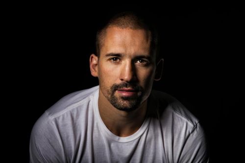 Tomáš Plekanec na portrétní fotografii s černým pozadím.