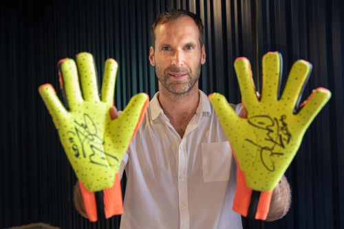 Petr Čech drží fotbalové golmanské rukavice s autogramy