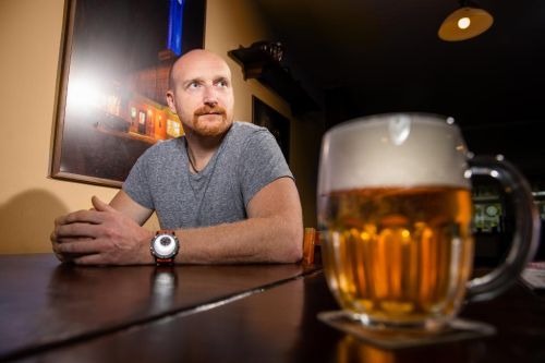 Radek Philipp sedí u stolu a má před sebou pivo 