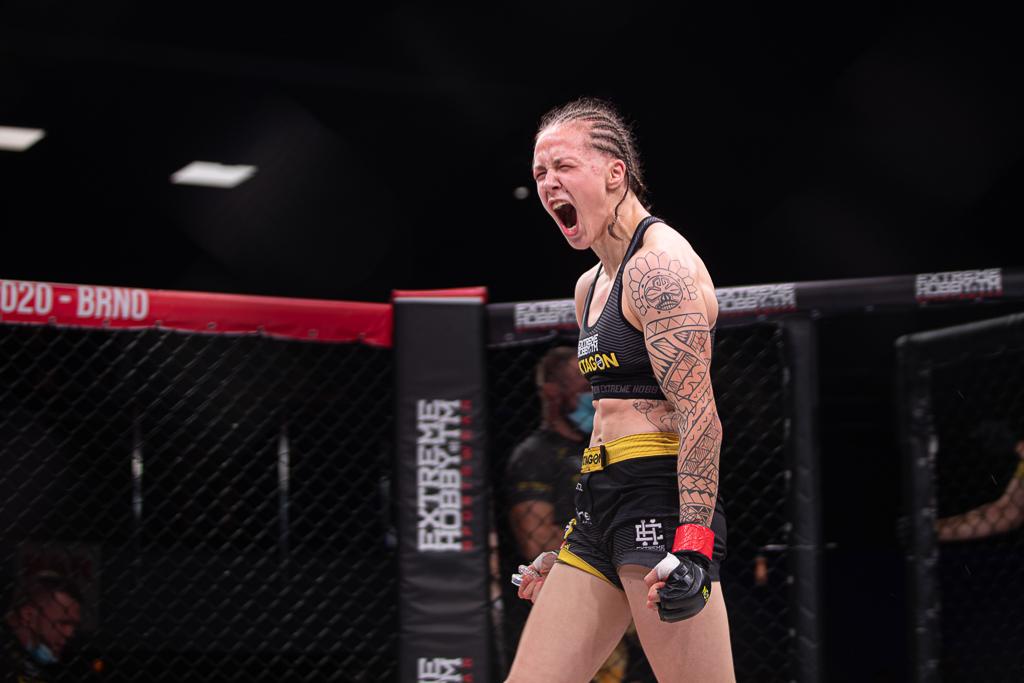 Tereza Bledá se raduje v kleci MMA, na ruce má tetování