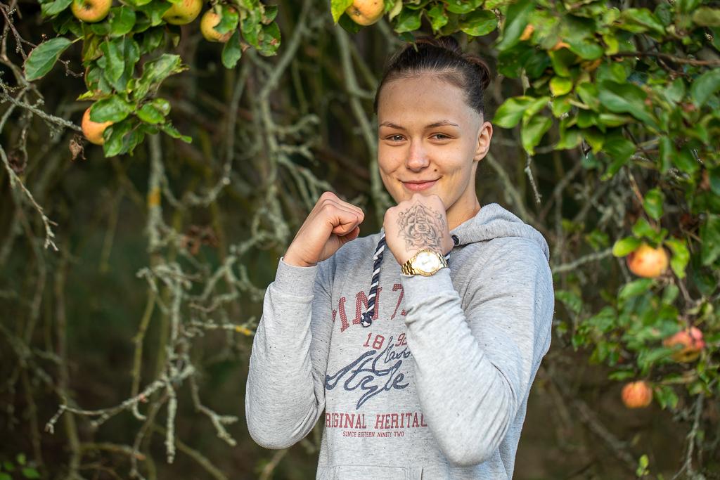 Tereza Bledá v bojovém postavení, na ruce má tetování, stojí pod jabloní