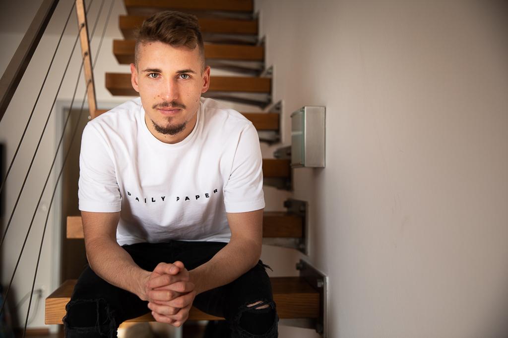 Michal Sadílek sedí na schodech v domě