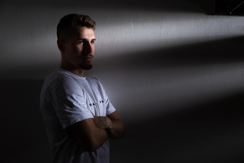 Michal Sadílek stojí u zdi, má na sobě stíny