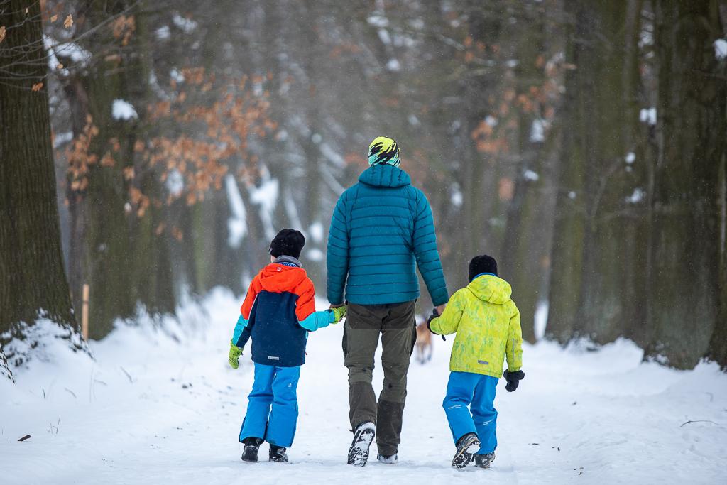 Ondřej Klymčiw se prochází se svými dětmi v zimě lesem