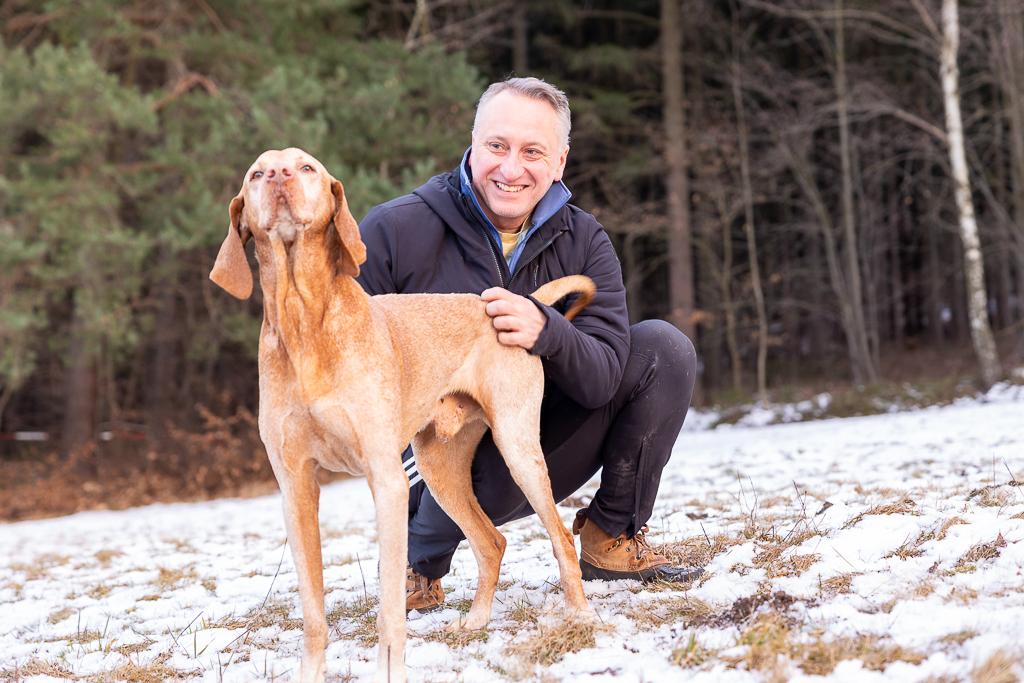 Václav Krejčík se psem na zasněžené louce před lesem