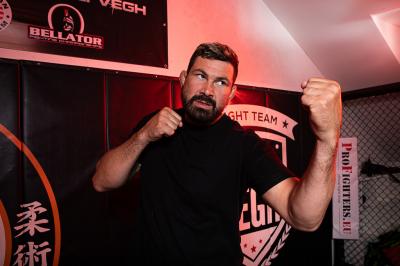 Attila Végh naznačuje box před logem svého týmu bojových umění