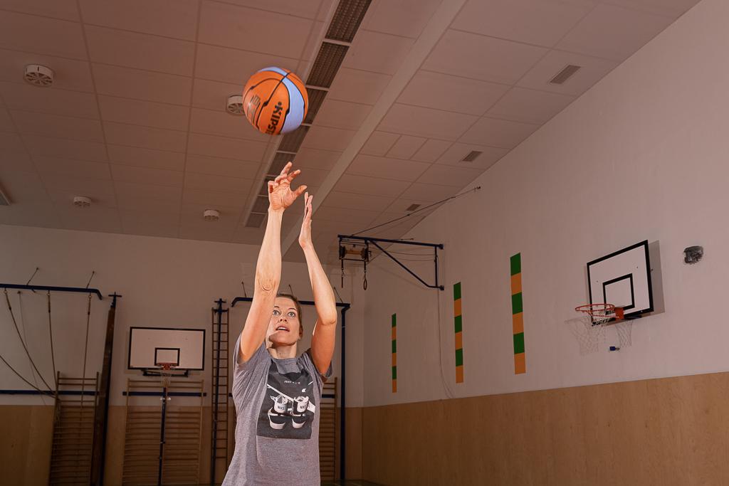 Ivana Večeřová hází basketbalovým míčem v tělocvičně