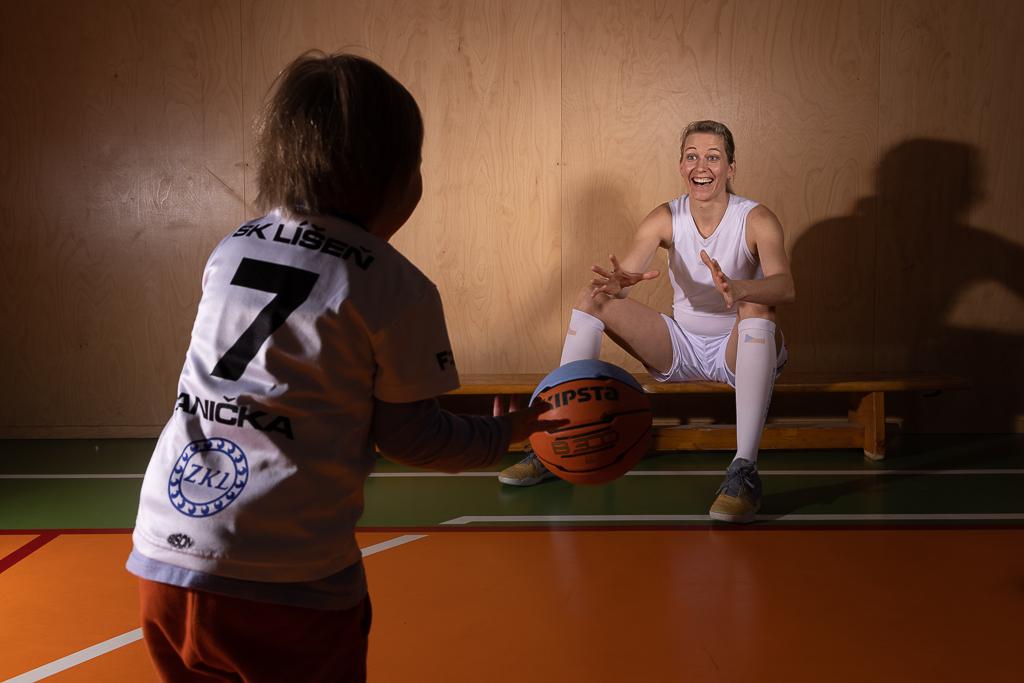 Ivana Večeřová chytá basketbalový míč, která jí hází dcera v tělocvičně