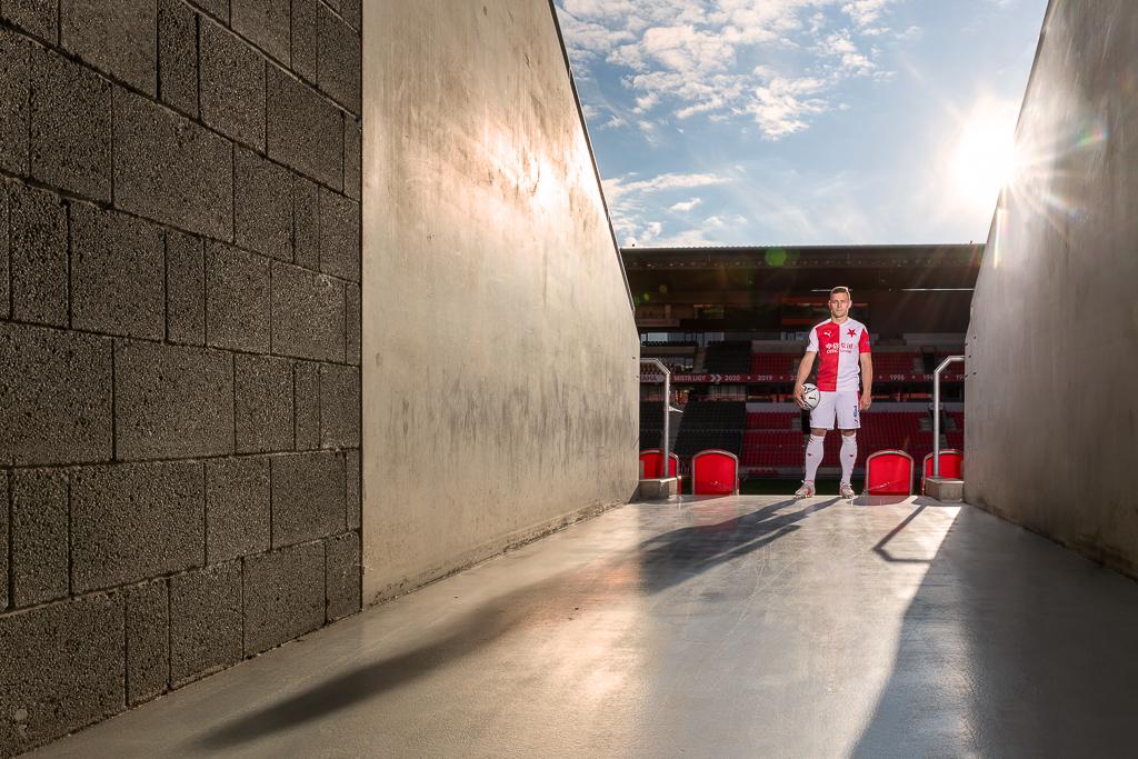 Tomáš Holeš v dresu Slavie s míčem na chodbě u hlediště na fotbalovém stadionu
