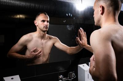 David Lischka stojí před zrcadlem v koupelně