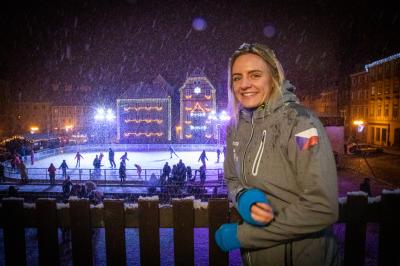 Markéta Jeřábková stojí u plotu na náměstí s výhledem na led, sněží
