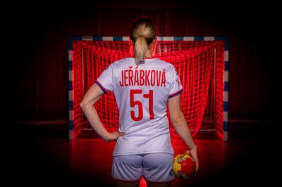 Markéta Jeřábková v házenkářském dresu číslo 51 ze zadu před brankou, drží míč