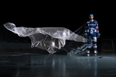 Petr Gewiese stojí na ledě, za ním vlaje igelitová plachta.
