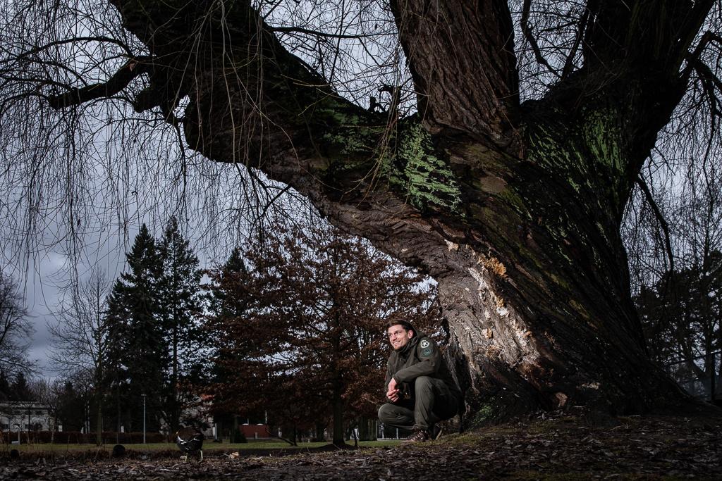 David Dvořák sedí u rybníka pod stromem.