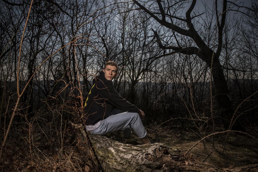 Jegor Cykalo sedí na zemi mezi stromovými kořeny.