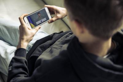 Jegor Cykalo sleduje na mobilu projev prezidenta Ukrajiny Volodomyra Zelinského.