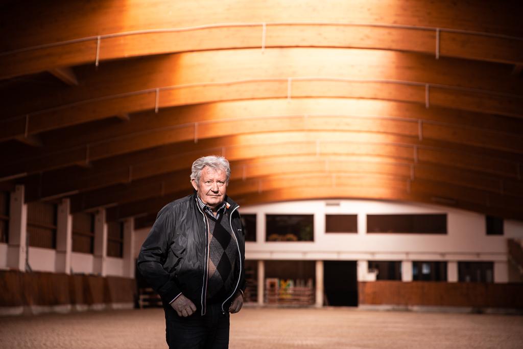 Jiří Pecháček stojí uprostřed jezdecké haly