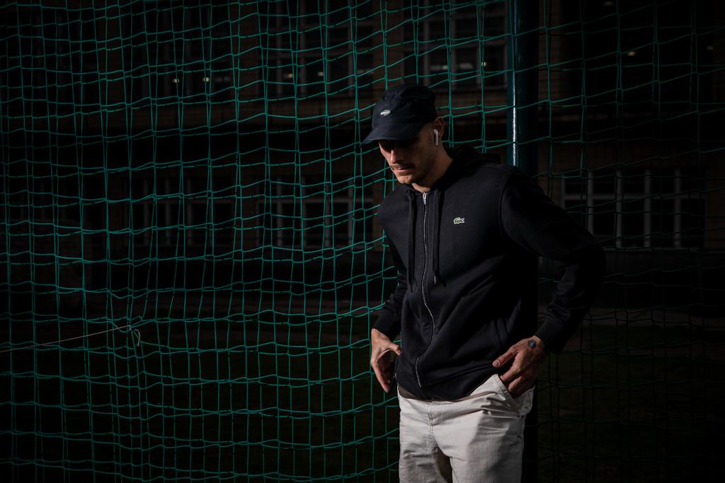 Tomáš Kučera na tmavé fotografii na sportovním hřišti.