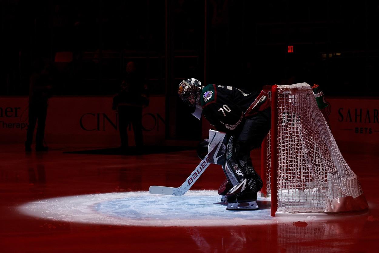 Karel Vejmelka v hokejové brankářské výstroji na ledě před bránou, svítí na něj světlo