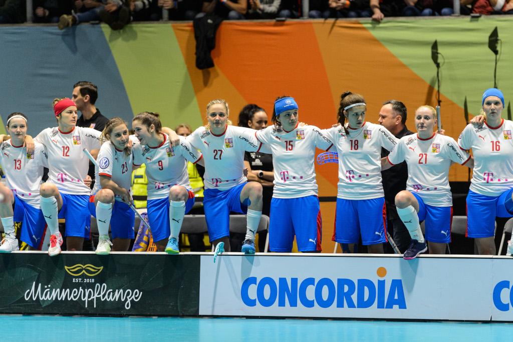 Natálie Martináková společně s ostatními hráčkami z týmu se na střídačce drží kolem ramen.